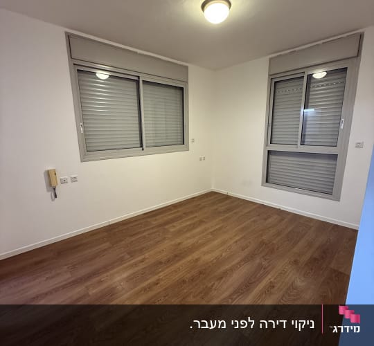 חדר ריק עם רצפת עץ וחלונות